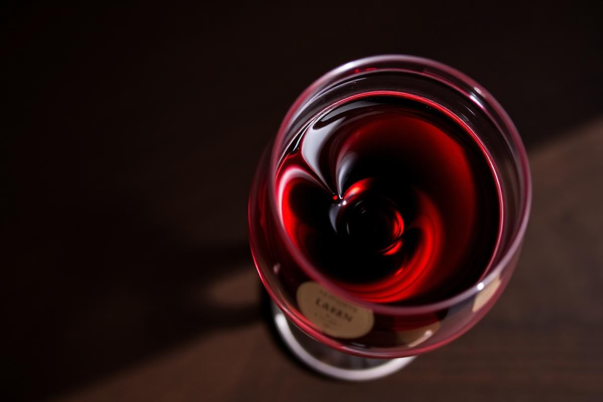 Red wine swirling in the bowl of a wine glass seen from above